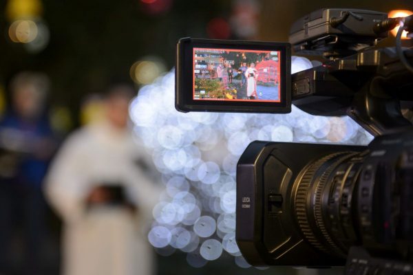 Varga András, a Salgótarjáni Katolikus Főplébánia esperes-plébánosa látszik egy kamera kijelzőjén az első adventi gyertya meggyújtásának televíziós felvételén Salgótarján főterén 2020. november 28-án (Fotó: MTI/Komka Péter)