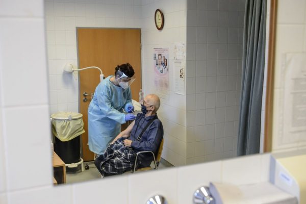 Almásyné Bakos Eszter szakápoló a Pfizer-BioNTech koronavírus elleni vakcinájának második adagjával olt be egy idős férfit a salgótarjáni Szent Lázár Megyei Kórház oltópontján 2021. február 27-én (Fotó: MTI/Komka Péter)