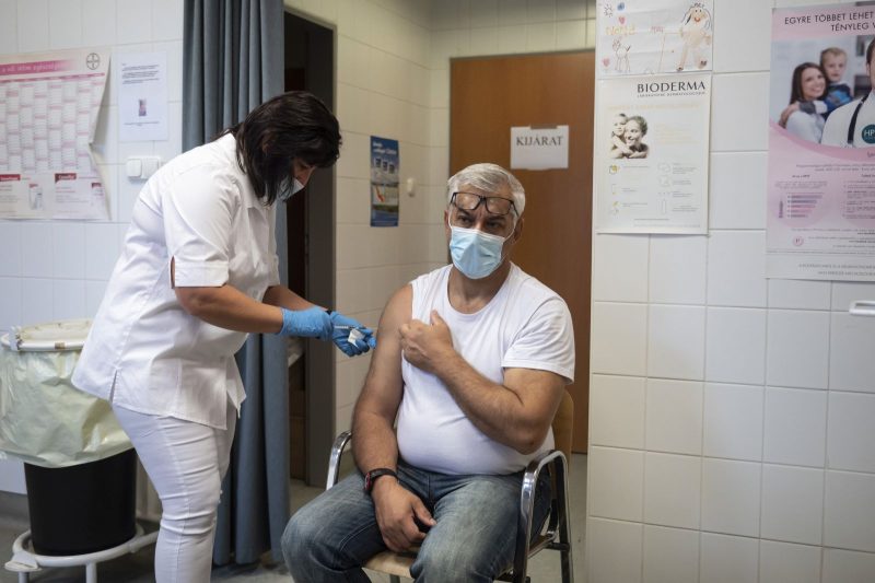 Beoltanak egy férfit a német-amerikai fejlesztésű Pfizer-BioNTech koronavírus elleni oltóanyag, a Comirnaty-vakcina első adagjával a salgótarjáni Szent Lázár Megyei Kórház oltópontján 2021. november 4-én (Fotó: MTI/Komka Péter)