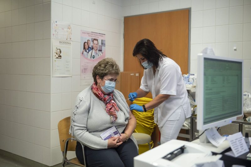 Beoltanak egy nőt a német-amerikai fejlesztésű Pfizer-BioNTech koronavírus elleni oltóanyag, a Comirnaty-vakcina harmadik, emlékeztető adagjával a salgótarjáni Szent Lázár Megyei Kórház oltópontján (Fotó: MTI/Komka Péter)