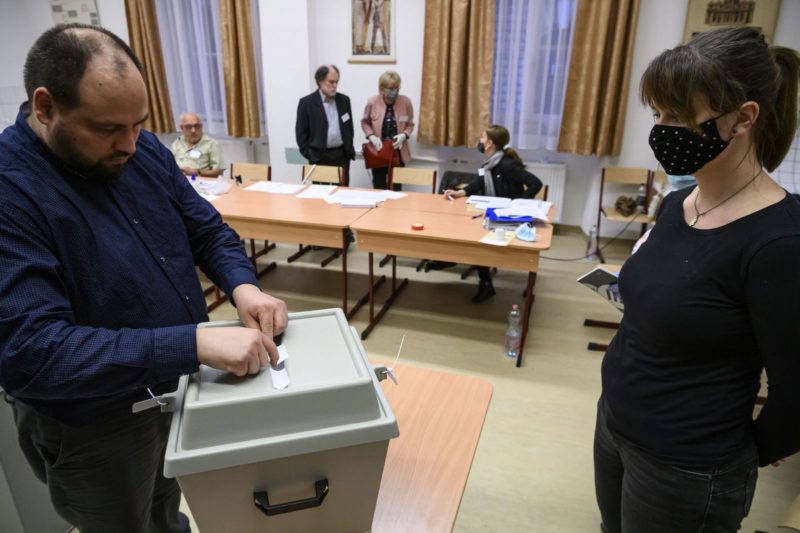 A szavazatszámláló bizottság tagjai zárócímkét helyeznek a szavazóurnákra a szavazóhelyiség bezárása után, mielőtt megkezdik a szavazatok számlálását az egyik budapesti szavazókörben (Fotó: MTI/Szigetváry Zsolt)