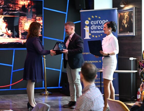 Balázs Beáta, a rádió műsorvezetője átveszi a „Nógrád megyében Európáért Díj” sajtódíját a Helyi Rádió Műsorszolgáltató Kft. nevében Fenyvesi Gábortól, a Fejlődő, Élhető és Szerethető Városért Egyesület elnökétől, valamint Fenyvesiné Mester Erikától, a Europe Direct Nógrád Információs Iroda vezetőjétől 2026. március 27-én. (Fotó: Europe Direct - Nógrád | Facebook)