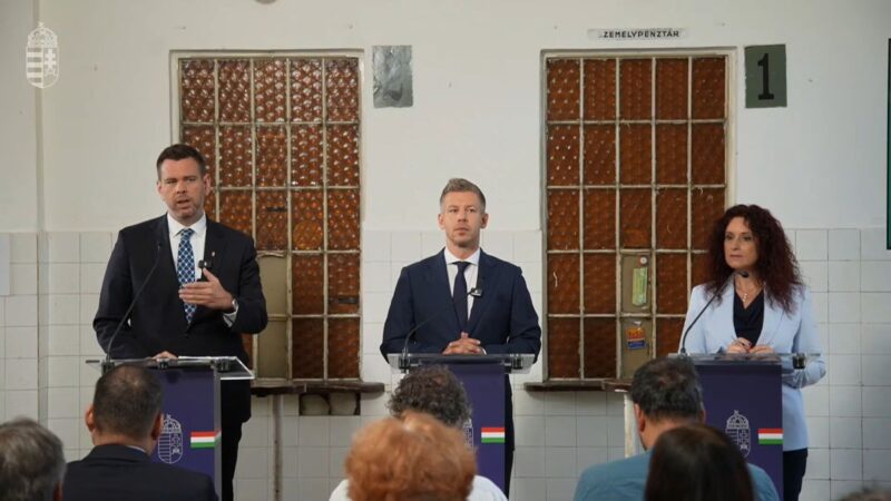 Vitézy Dávid közlekedési és beruházási miniszter, Magyar Péter miniszterelnök és Magyar Éva kormányszóvivő a Baross Gábor Vasútfejlesztési Terv kapcsán tartott sajtótájékoztatón a Rákospalota-Újpest vasútállomáson, 2026. július 22-én. (Fotó forrása: Magyarország Kormánya | YouTube)